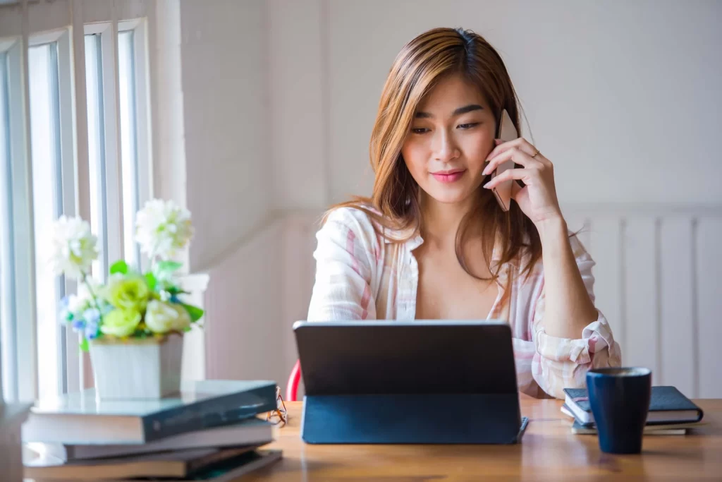 advice & guidance consultations. woman on her computer and mobile at a desk