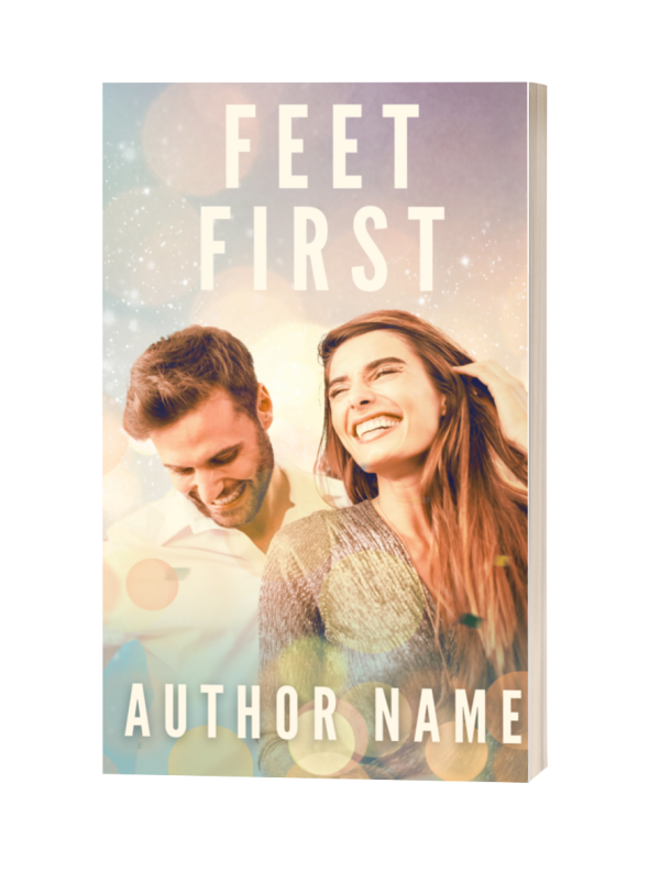 A premade book cover titled "Feet First: Premade Ebook & Paperback Book Cover" features a smiling couple in the foreground. The man has short hair and a beard, wearing a white shirt, looking down. The woman has long hair, light sweater, looking cheerfully forward. The background is a soft blend of pastel colors and light bokeh effects. Author name is at the bottom. BookSelf Book Cover Design & Premade Book Covers