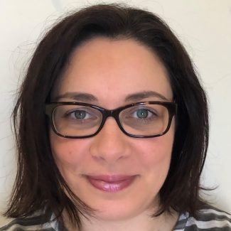 A woman with shoulder-length dark brown hair is smiling at the camera, showcasing her profile. She is dressed in a gray and white striped top, wearing black-framed glasses and light pink lip gloss. The background is a plain white wall, highlighting her as though she were a poised designer. BookSelf Book Cover Design & Premade Book Covers A woman with shoulder-length dark brown hair is smiling at the camera, showcasing her profile. She is dressed in a gray and white striped top, wearing black-framed glasses and light pink lip gloss. The background is a plain white wall, highlighting her as though she were a poised designer. BookSelf Book Cover Design & Premade Book Covers